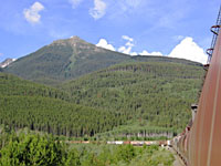 tall mountain with train going toward it